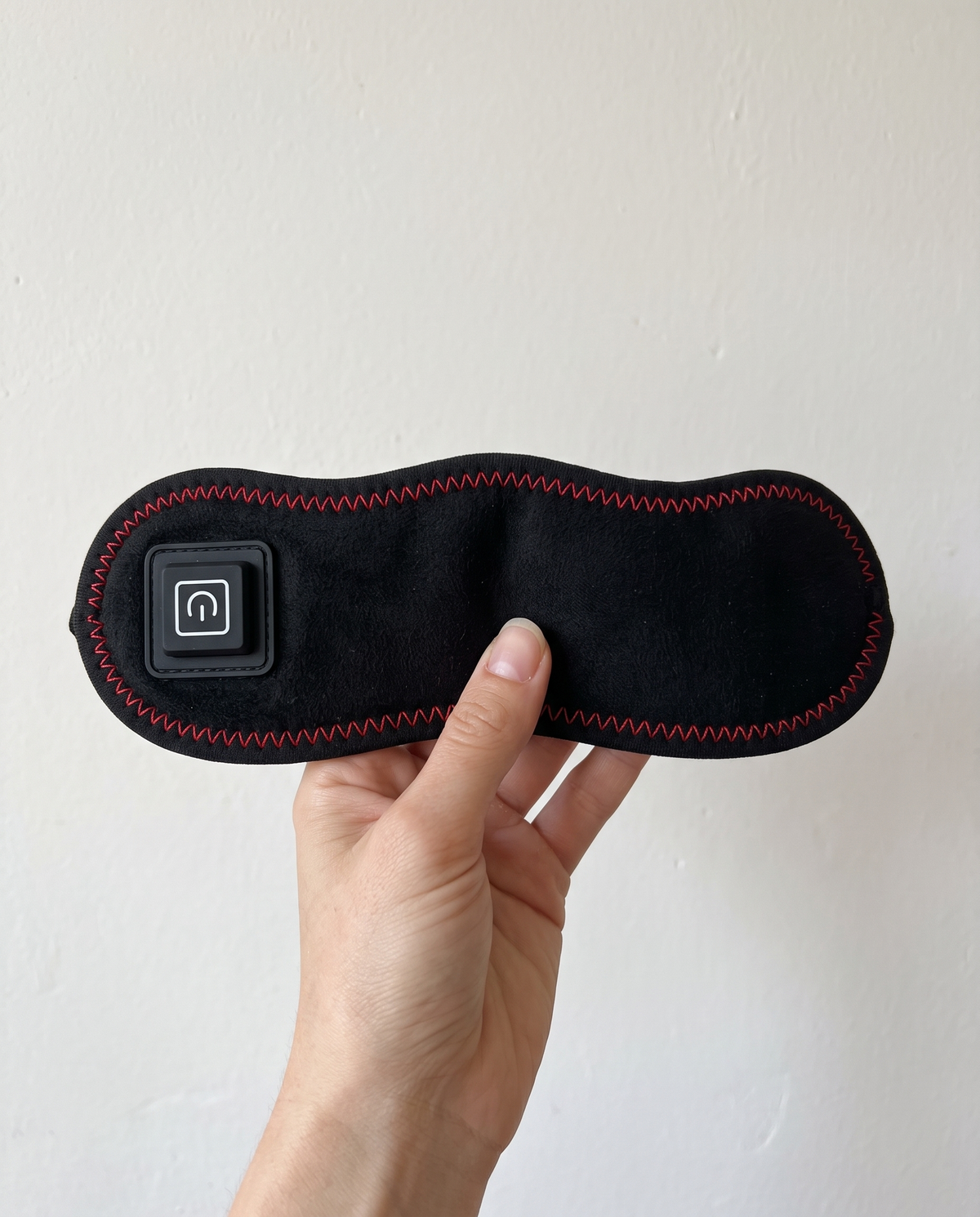 The Sinuglow wrap held in a hand to show its size